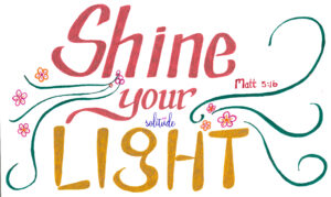 the words, "Shine Your Light"  written in Red and Gold with green swirls on both sides and flowers on the left side